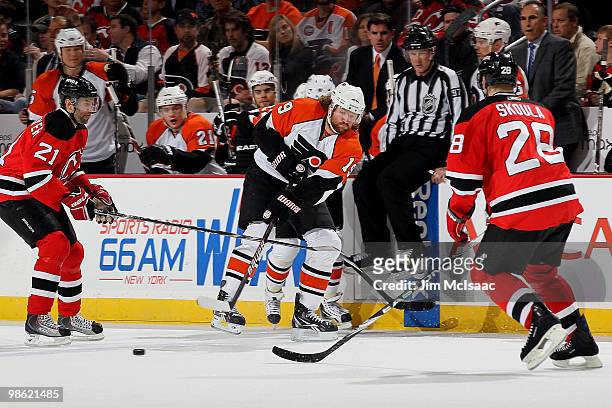 Scott Hartnell of the Philadelphia Flyers handles the puck against Martin Skoula and Rob Niedermayer of the New Jersey Devils in Game 5 of the...