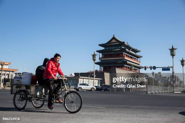 Cyclists ride their bikes past Qianmen in Beijing, China, on Tuesday, Dec. 01, 2015.