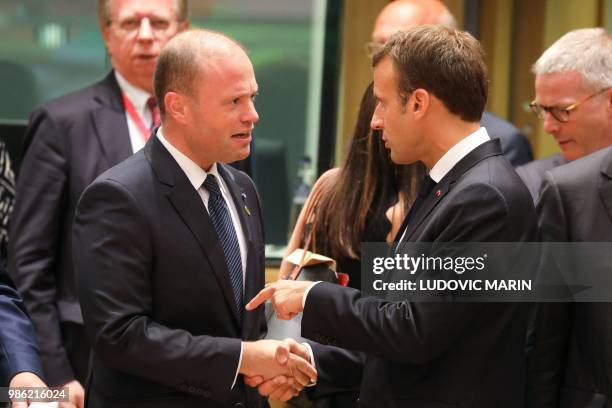 France's President Emmanuel Macron speaks with Malta's Prime Minister Joseph Muscat during an European Union leaders' summit focused on migration,...