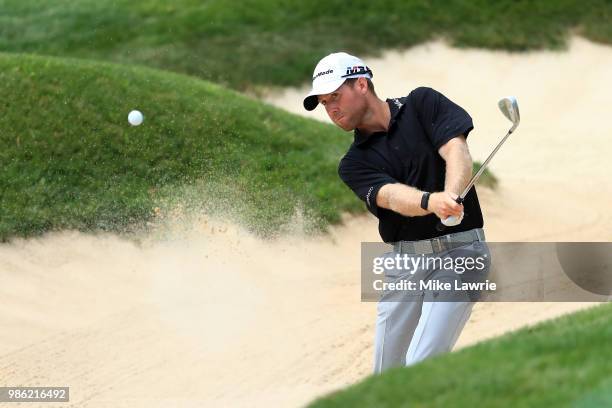 Tyler Duncan hits out of a bunker on the 14th hole during the first round of the Quicken Loans National at TPC Potomac on June 28, 2018 in Potomac,...