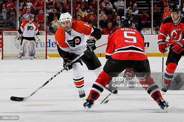 Ian Laperriere of the Philadelphia Flyers handles the puck against Colin White of the New Jersey Devils in Game 5 of the Eastern Conference...