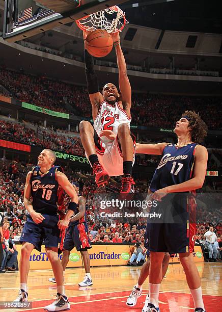 Taj Gibson of the Chicago Bulls dunks past Anthony Parker and Anderson Varejao of the Cleveland Cavaliers in Game Three of the Eastern Conference...