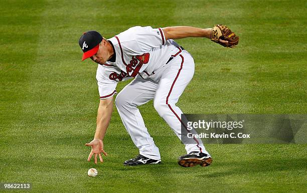 Chipper Jones of the Atlanta Braves scoops up a bunted ball against the Philiadelphia Phillies at Turner Field on April 22, 2010 in Atlanta, Georgia.