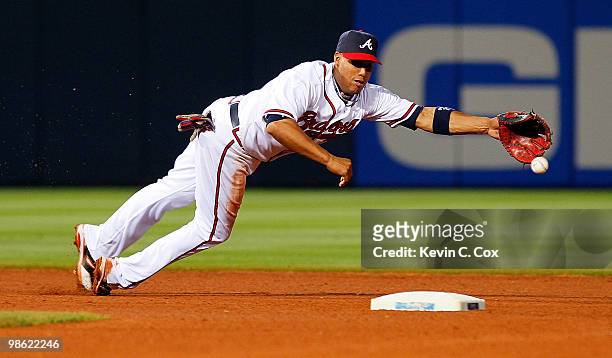 Yunel Escobar of the Atlanta Braves dives for a ground ball over second base by the Philiadelphia Phillies at Turner Field on April 22, 2010 in...