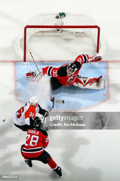 Martin Brodeur of the New Jersey Devils makes a save against Darroll Powe of the Philadelphia Flyers in Game 5 of the Eastern Conference...