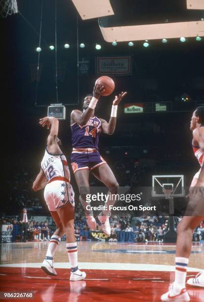 Alvin Scott of the Phoenix Suns shoots over Greg Ballard of the Washington Bullets during an NBA basketball game circa 1985 at the Capital Centre in...