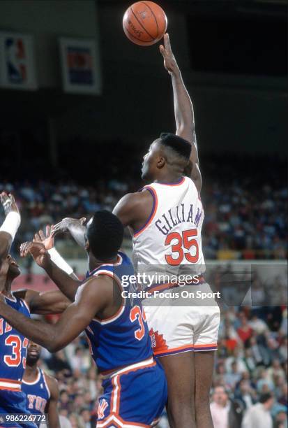 Armen Gilliam of the Phoenix Suns shoots over Charles Oakley and Patrick Ewing of the New York Knicks during an NBA basketball game circa 1988 at the...