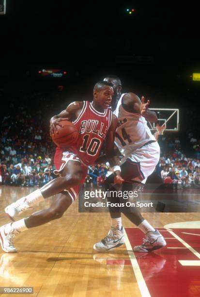 Armstrong of the Chicago Bulls drives on A.J. English of the Washington Bullets during an NBA basketball game circa 1990 at the Capital Centre in...