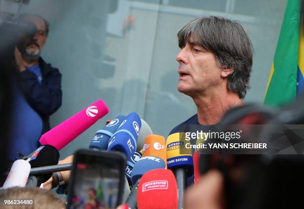 Germany's head coach Joachim Loew talks to media as he arrives at Frankfurt international airport on June 28 after flying back from Moscow following...