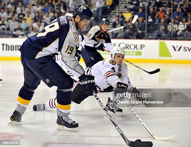 Niklas Hjalmarsson of the Chicago Blackhawks reaches in to poke the puck away from Jason Arnott of the Nashville Predators in Game Four of the...