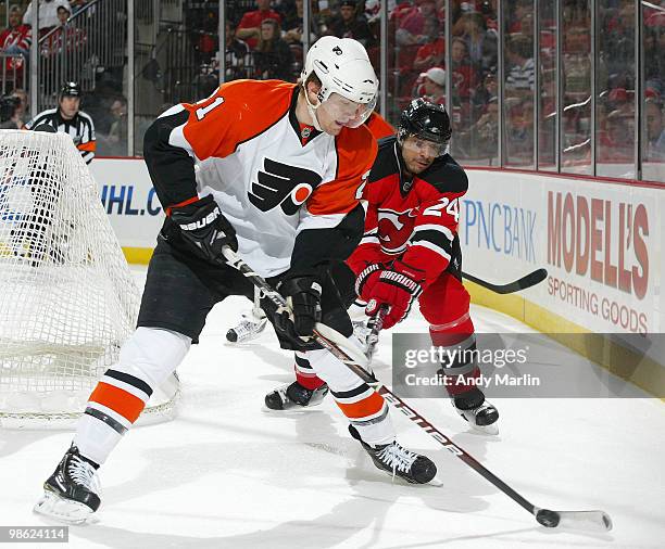 James van Riemsdyk of the Philadelphia Flyers plays the puck while being sticked checked by Bryce Salvador of the New Jersey Devils in Game Five of...