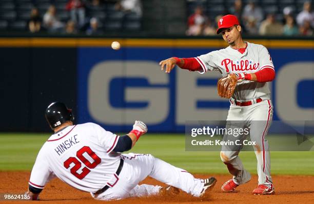 Juan Castro of the Philiadelphia Phillies turns a double play over Eric Hinske of the Atlanta Braves at Turner Field on April 22, 2010 in Atlanta,...