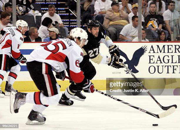 Craig Adams of the Pittsburgh Penguins back checks on Erik Karlsson of the Ottawa Senators in Game Five of the Eastern Conference Quarterfinals...