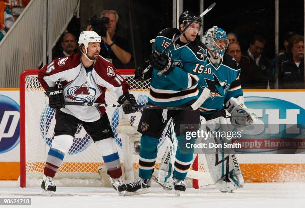 Darcy Tucker of the Colorado Avalanche watches the puck against Dany Heatley and Evgeni Nabokov of the San Jose Sharks in Game Five of the Western...