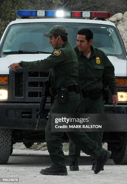 Two US Border Patrol officers track the path of illegal aliens who have crossed into the US from Mexico near the town of Nogales, Arizona on April...