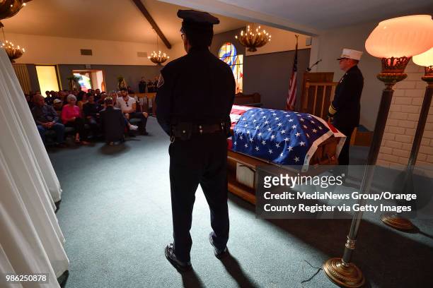 Long Beach Chief of Police Robert Luna, left, and Fire Chief Mike Duree, right, stand by Long Beach Fire Captain Dave Rosa's casket at McCormick &...