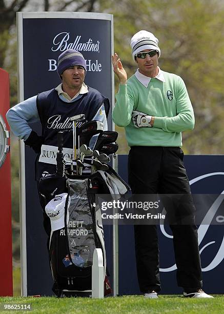 Brett Rumford of Australia talks with his caddie on the 17th tee during the fog-delayed Round One of the Ballantine's Championship at Pinx Golf Club...