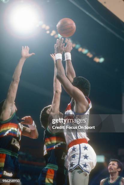 Bill Hanzlik of the Denver Nuggets leaps to defend the shot of Cliff Robinson of the Washington Bullets during an NBA basketball game circa 1985 at...