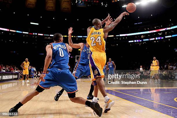 Kobe Bryant of the Los Angeles Lakers passes the ball away from the press of Russell Westbrook and Thabo Sefolosha of the Oklahoma City Thunder...