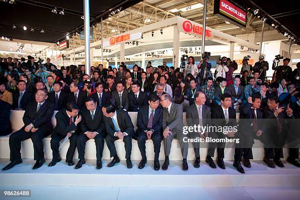 Dignitaries from SAIC Motor Corp. And General Motors Corp., front row, attend an event at the SAIC booth at the Beijing Auto Show in Beijing, China,...