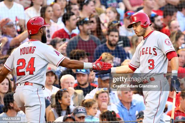 Chris Young high fives Ian Kinsler of the Los Angeles Angels after hitting a solo home run in the third inning of a game against the Boston Red Sox...