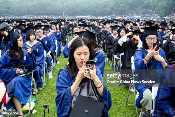 Graduate reapplies makeup and lipstick during the graduation ceremony of Wuhan University on June 22, 2018 in Wuhan, Hubei Province of China. Over...