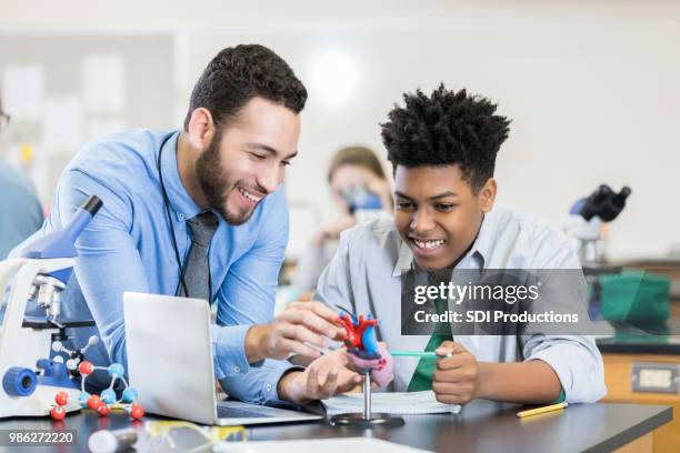 teenage boy receives help from attentive science teacher - organe de reproduction masculin imagens e fotografias de stock