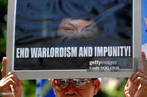 An activist holds a placard with a picture of Maguindanao massacre suspect Andal Ampatuan Jnr. At a rally at the Department of Justice in Manila on...