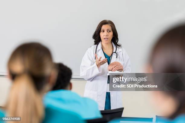 confident female doctor gives presentation during healthcare conference - neurologist stock pictures, royalty-free photos & images