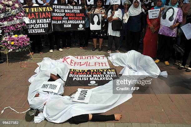 Indonesians lie on the ground 'playing dead' during a protest in front of the Malaysian embassy against the Malaysian government in Jakarta on April...