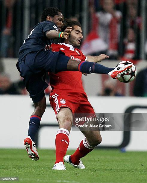 Hamit Altintop of Muenchen is challenged by Michel Bastos of Lyon during the UEFA Champions League semi final first leg match between FC Bayern...
