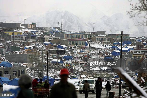 Residents walk by the rubble of quake-destroyed homes in Jiegu, Yushu county, in China's northwestern province of Qinghai on April 22, 2010. China...