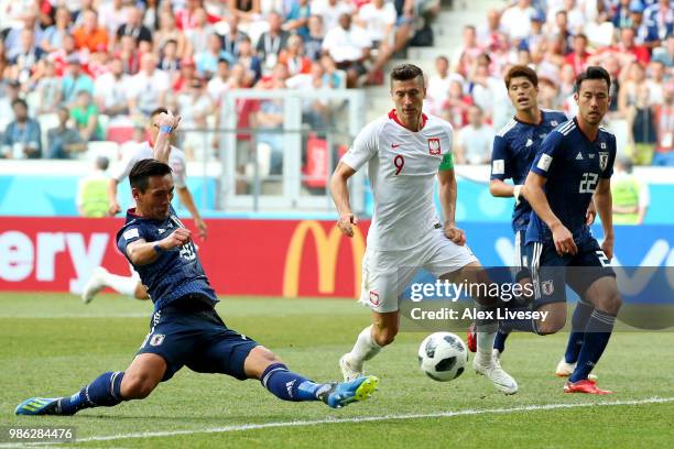Tomoaki Makino of Japanclears the ball under pressure from Robert Lewandowski of Poland during the 2018 FIFA World Cup Russia group H match between...