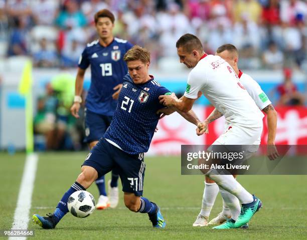 Gotoku Sakai of Japan is challenged by Artur Jedrzejczyk of Poland during the 2018 FIFA World Cup Russia group H match between Japan and Poland at...