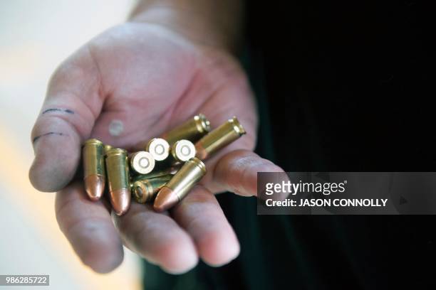 Trainee holds bullets in his hand before reloading a magazine during a three-day firearms training course for teachers and administrators offered by...