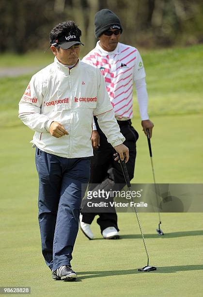Thongchai Jaidee of Thailand and Y.E. Ynag of Korea wait to putt on the 13th green during the fog-delayed Round One of the Ballantine's Championship...