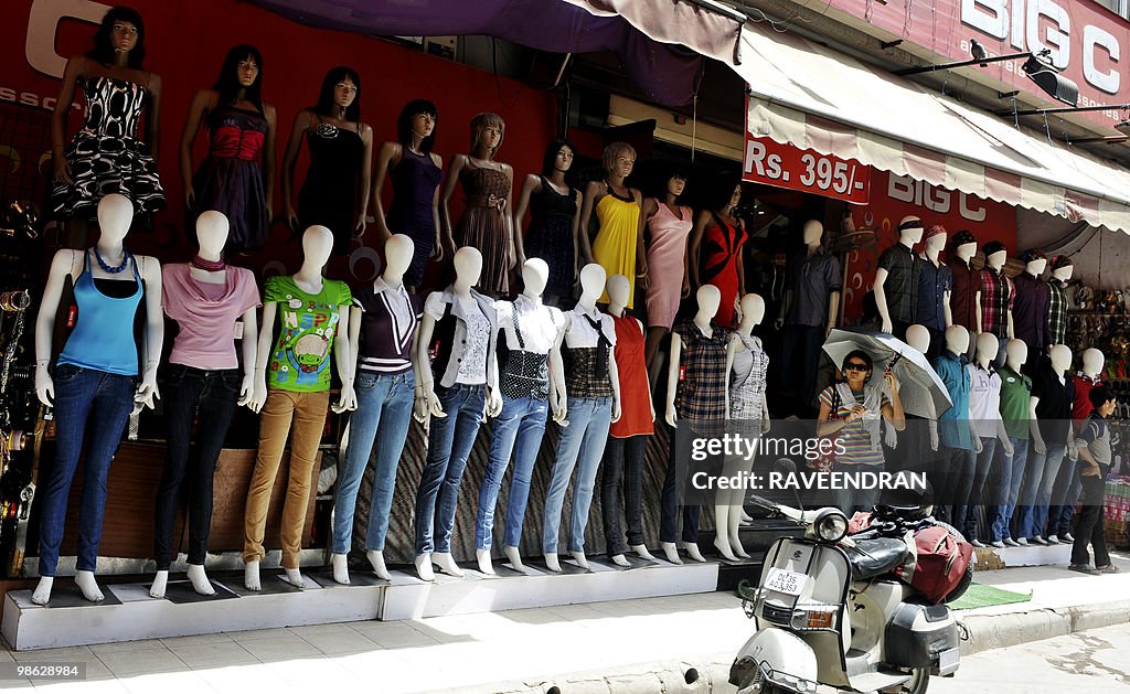 Indian pedestrians walk past mannequins