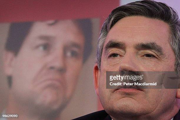 Prime Minister Gordon Brown sits in front of a photograph of Liberal Democrat leader Nick Clegg as he speaks to reporters, as the Labour Party...