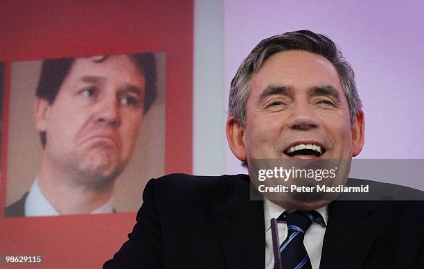 Prime Minister Gordon Brown sits in front of a photograph of Liberal Democrat leader Nick Clegg as he speaks to reporters, as the Labour Party...