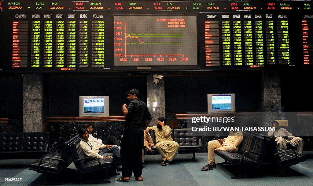 Pakistani stockbrokers discuss under a l