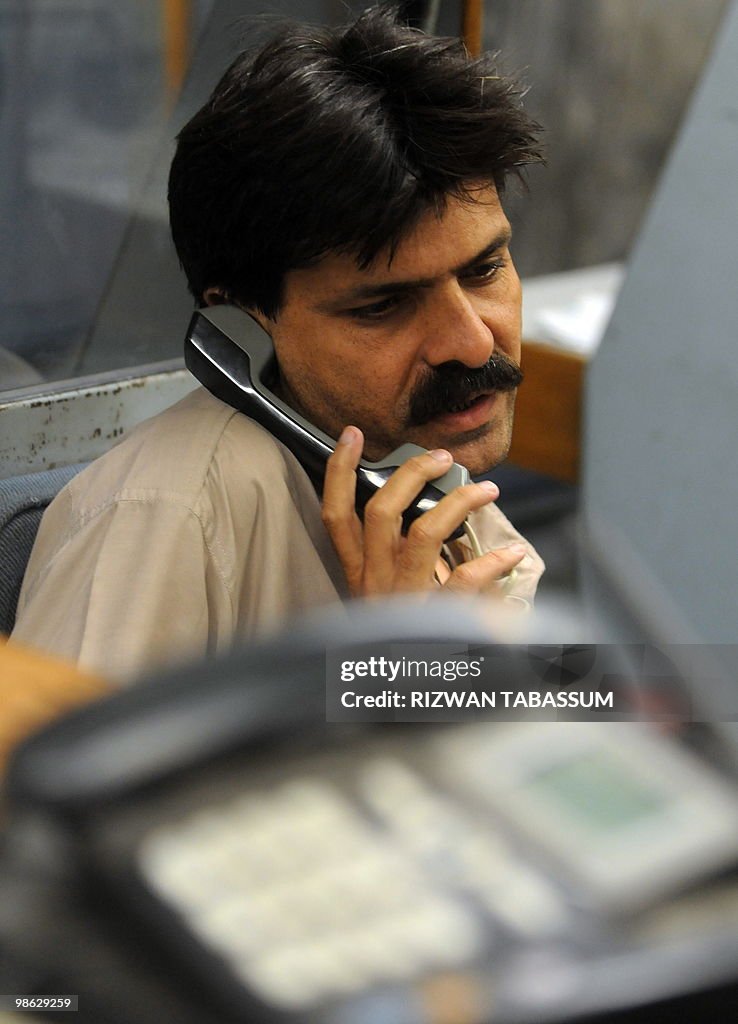 A Pakistani stockbroker talks to a clien