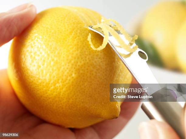 zesting a lemon - scorza di limone foto e immagini stock