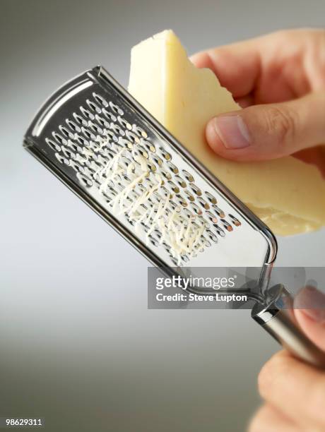 grating cheese with a cheese grater - grattugia foto e immagini stock