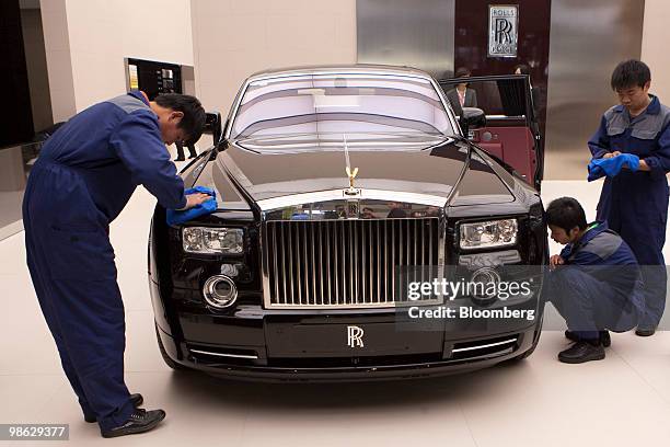 Workers polish a Rolls Royce Motor Cars vehicle at the Beijing Auto Show in Beijing, China, on Friday, April 23, 2010. Rolls Royce said sales rose...