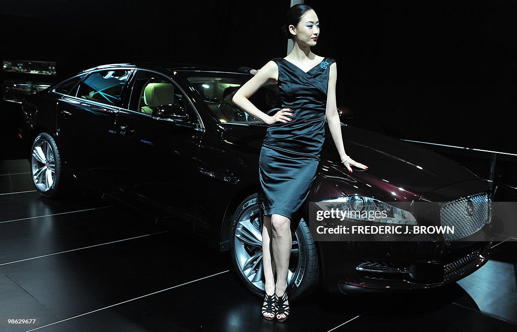 A model poses besides a Jaguar XJL durin