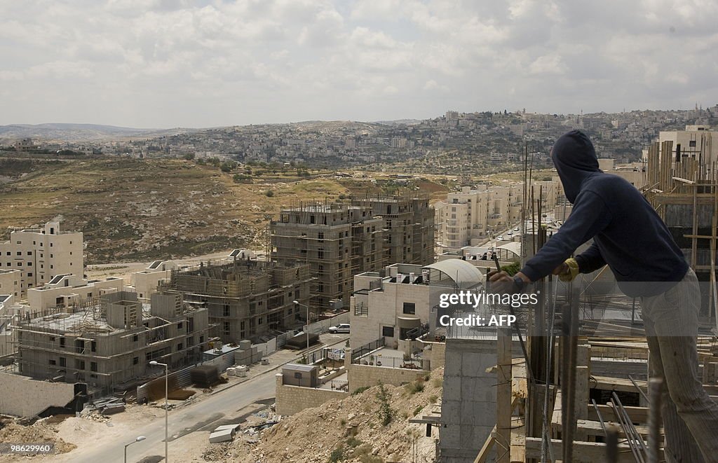 Palestinian labourers work on a new hous