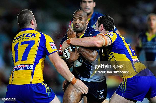 Michael Bani of the Cowboys is tackled by Justin Poore and Nathan Cayless of the Eels during the round seven NRL match between the North Queensland...