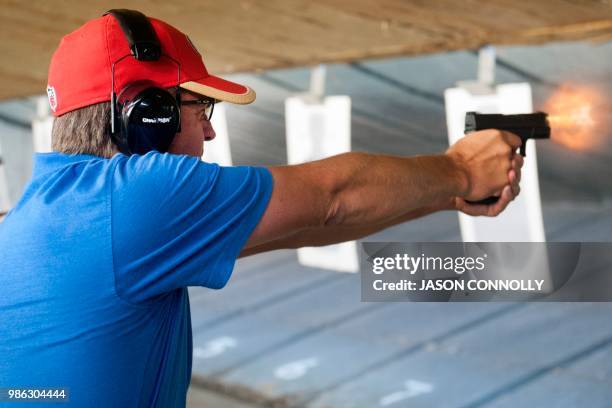 Wayne , a facility maintenance employee with a central Colorado school, fires his gun during a firearms course for school teachers and administrators...