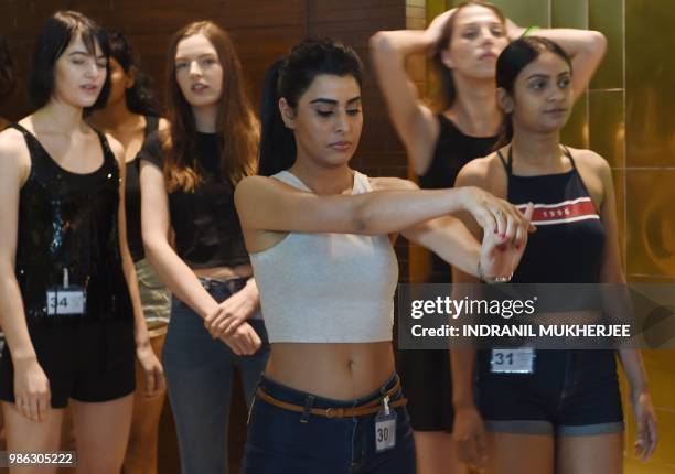 Model stretches her arms while waiting for the Lakmé Fashion Week Winter/Festive 2018 edition model auditions in Mumbai on June 28, 2018. - Lakmé...