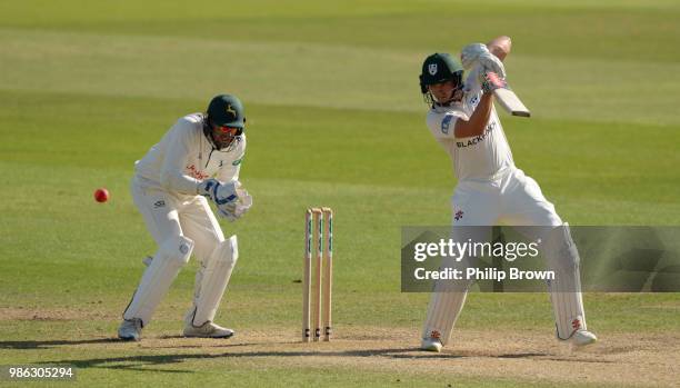 Joe Clarke of Worcestershire hits out watched by Riki Wessels of Nottinghamshire during the Specsavers County Championship Division One match between...